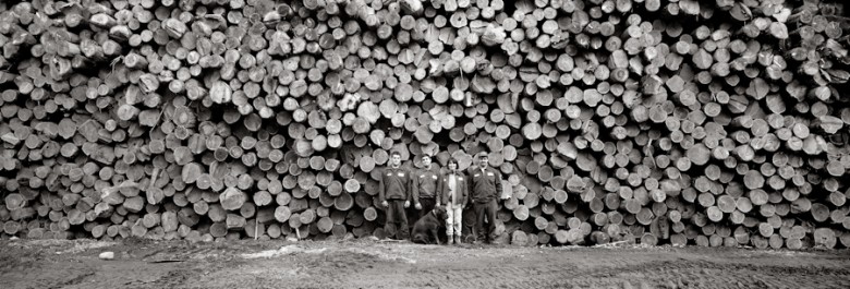 Colleen Goodridge and her sons surrounded by of a wall of white pine logs harvested locally at their lumber mill in Albany, 1999.