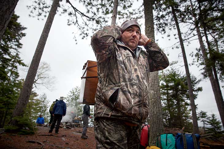 Chris (“Charlie Brown”) Francis carries a wanigan filled with heavy supplies. A master moose caller and hunter, Charlie Brown could have fed everyone from the forest, Mike Wilson said. “We could not have done this trip,” he noted, “without the Penobscot Nation.”
