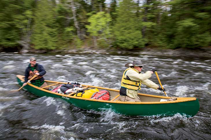 Guide Glen Horne (stern) and Penobscot guide James Francis paddle through one of many rapids along the route. Wrote the L.O.G., “We started out fearful, inexperienced on rapids … But through time, patient teaching, and experience, we learned how to stop, scout, read the water, pick our line, paddle, eddy turn, and all sorts of other new river skills. We even had a rescue, and it went textbook.”