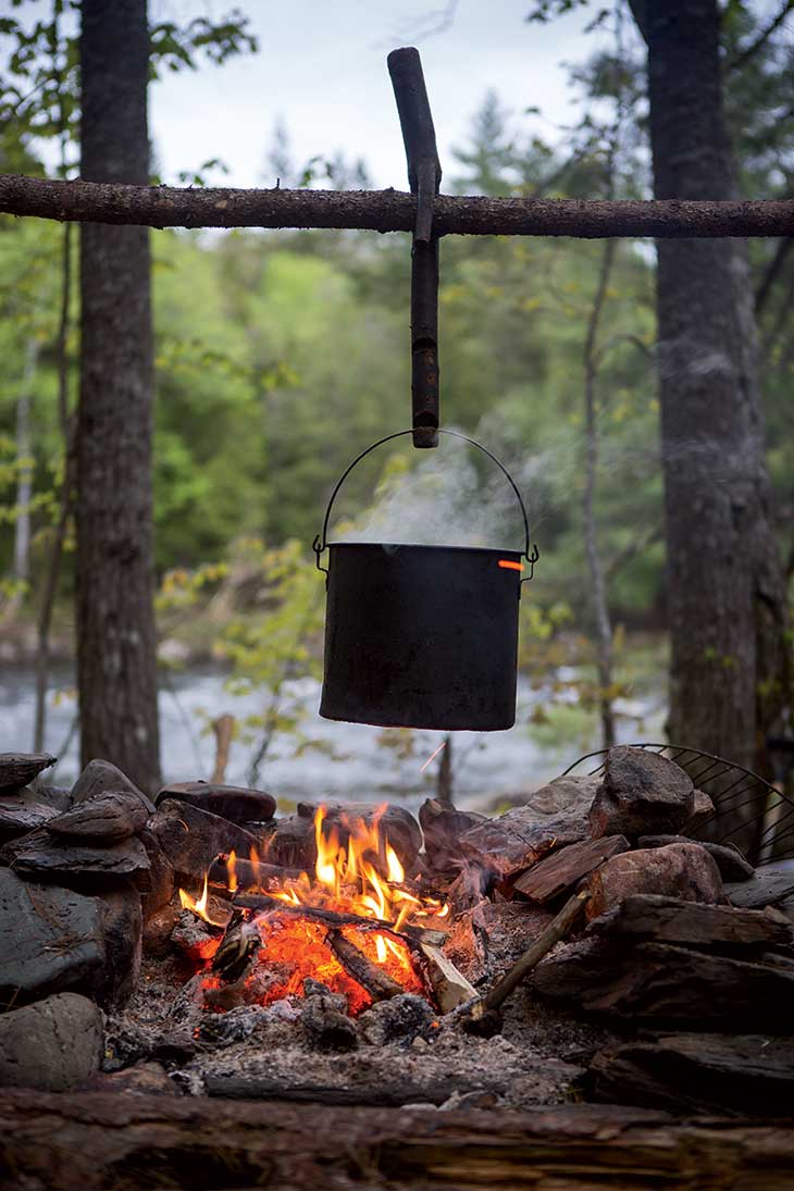 Steaming pots simmered over the open flames of the campfire. 