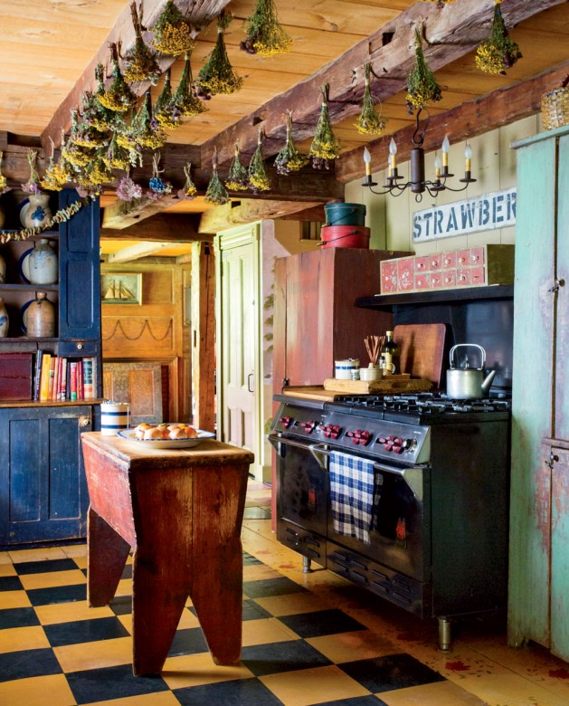 In front of the Wolf range, a vintage breadbox serves as the kitchen’s center island; the blue hutch conceals an under-the-counter fridge. (The large one was banished to the basement to make room for an 18th-century cupboard.) 