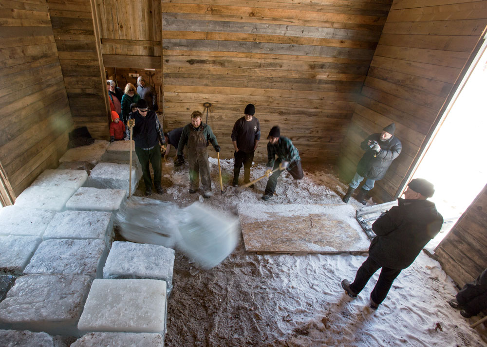  Inside the icehouse, reconstructed with salvaged wood, workers stack the 300-pound blocks.