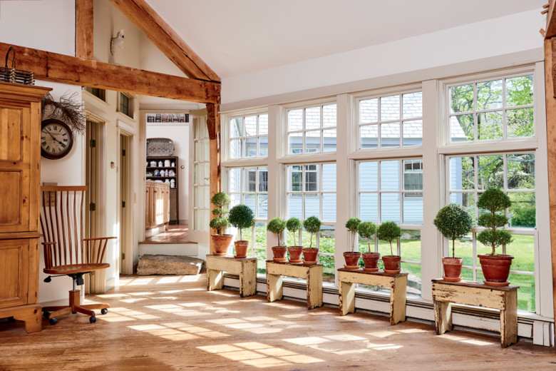 Myrtle topiaries march along the wall of windows in Bach’s “office,” which connects the house to the custom-built studio where she crafts her jewelry designs.