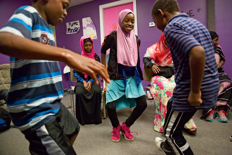 Sixth-grader Atika, originally from Somalia, dances with friends at the youth center.
