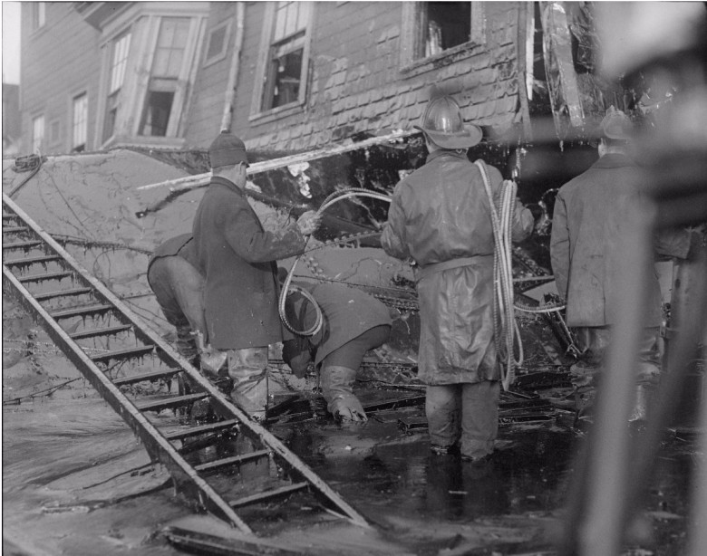 Firemen standing in thick molasses after the disaster.