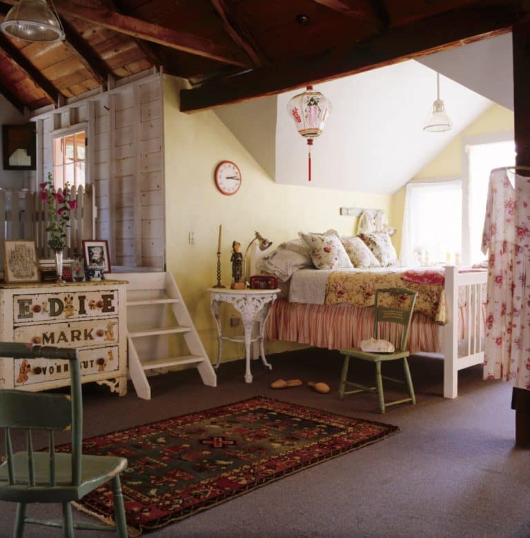 The third-floor master bedroom, with its simple painted bedstead covered in vintage textiles.