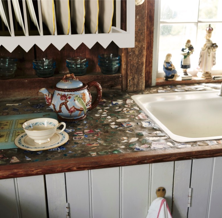 The countertop next to the kitchen sink in edie and John’s home was created by embedding pieces of old plates and crockery in cement.